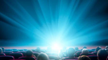 viewers watch shining light at the cinema, long exposure, blue glow